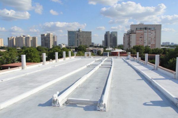 Commercial roofing contractor inspecting a flat roof system in Grand Prairie, TX.