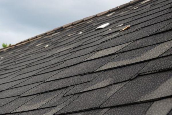 Roof in Murphy TX showing hail damage with cracked shingles and scattered debris after a storm, SCR, Inc.