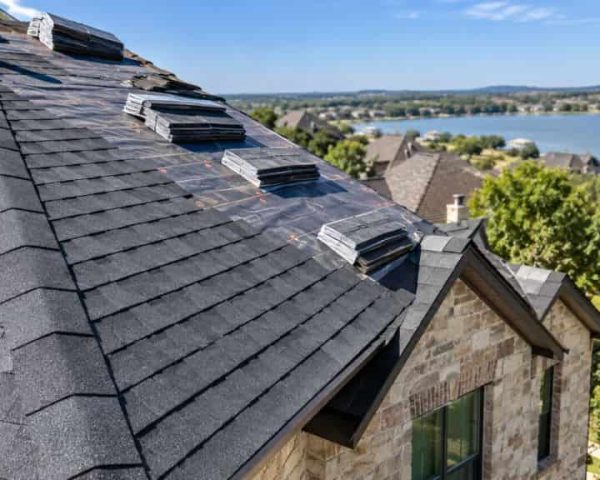 Architectural shingles stacked across a residential roof during an active roof replacement project.