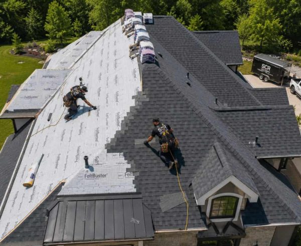 Roofing crew installing architectural shingles on a residential roof during a roof replacement in Ponder, TX.